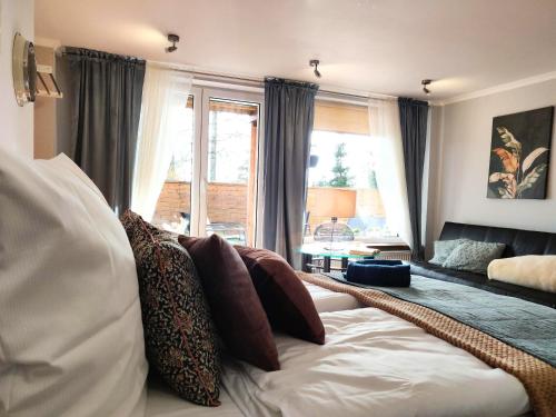 a living room with a couch with pillows on it at SB Apartment with Sauna in Kołobrzeg