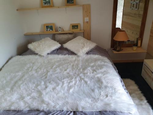 ein Bett mit einer weißen Bettdecke und Kissen in der Unterkunft La Terrasse in Fully