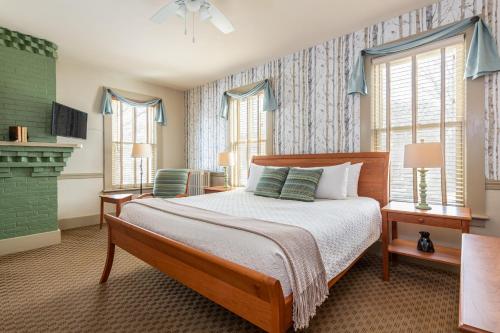 a bedroom with a bed and two windows at The Norwich Inn in Norwich