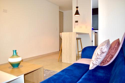 a living room with a blue couch and a table at Apartamento con vista y ubicación privilegiada in Armenia