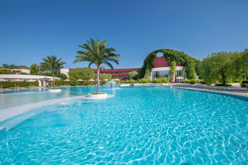 una piscina en un complejo con palmeras en Ethra Reserve Calanè en Castellaneta Marina 