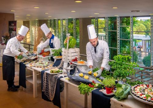 un grupo de chefs que preparan comida en una cocina en Ethra Reserve Calanè en Castellaneta Marina 