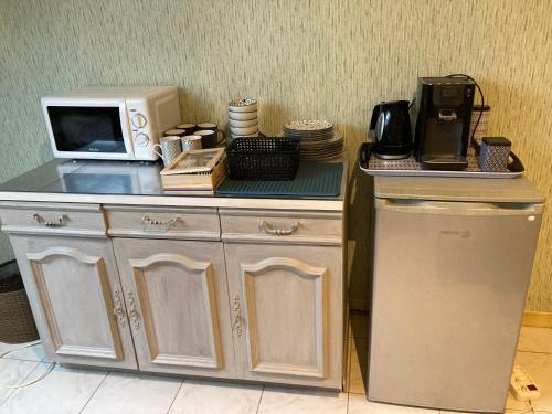 - un four micro-ondes installé au-dessus d'un comptoir à côté d'un réfrigérateur dans l'établissement chambre d'hôte du moulin, à Dieue-sur-Meuse