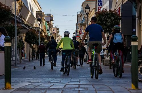 a group of people riding bikes down a street at Kalamata Art Rooms in Kalamata