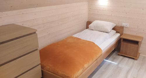 a small room with a small bed and a desk at BURSZTYNOWO Domy z saunami i jakuzzi in Ostrowo