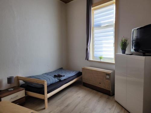 ein kleines Schlafzimmer mit einem Bett und einem TV in der Unterkunft Günstige Monteurwohnung in Bad Grund in Bad Grund