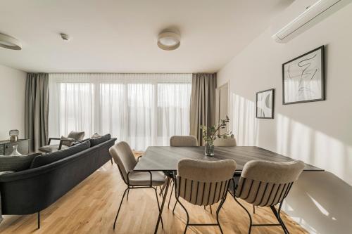 a living room with a dining room table and a couch at Arbio I Liv's Place Lux Apartments in Vienna