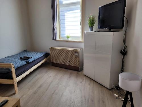 Kleines Zimmer mit einem Bett und einem TV auf einem Schrank in der Unterkunft Günstige Monteurwohnung in Bad Grund in Bad Grund