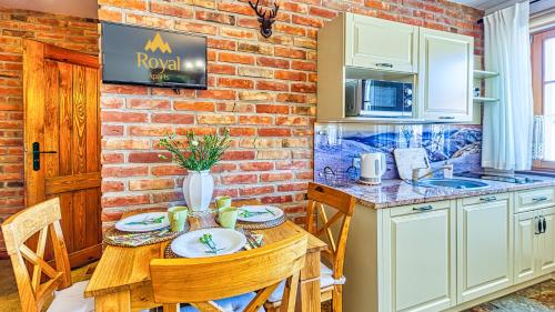 a kitchen with a table and a brick wall at Aparthotel STARA PIEKARNIA by ROYAL APARTS in Szklarska Poręba