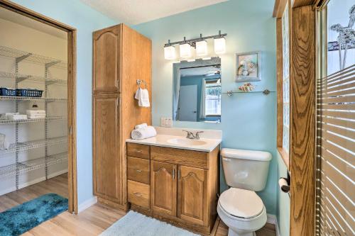 a bathroom with a toilet and a sink and a mirror at Colorful Cape Coral Retreat with Screened Lanai! in Cape Coral