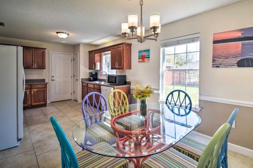 a kitchen and dining room with a glass table and chairs at Foley Getaway with Fenced Yard - 13 Mi to Beaches! in Foley