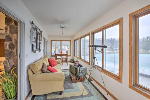 a living room with a couch and windows at Lakefront Newaygo Home - Private Dock, Kayaks in Newaygo