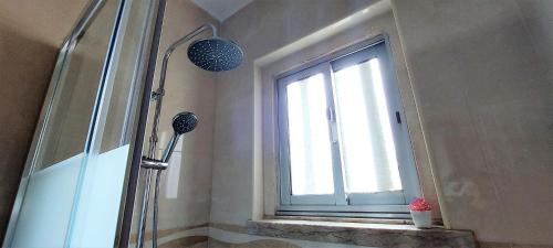 a shower in a bathroom with a window at Stone House - Sintra Rural in Sintra