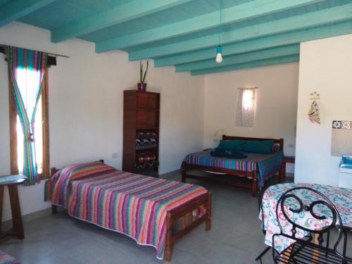 a bedroom with two beds and a blue ceiling at El Cardón,monoambiente en el campo in Humahuaca