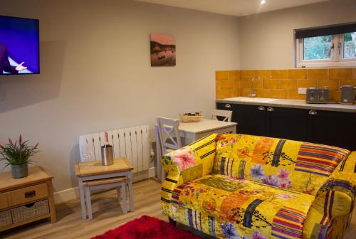 ein Wohnzimmer mit einem Sofa und einer Küche in der Unterkunft Creekside Lodge Bathpool Launceston Cornwall in Launceston