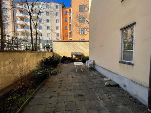 a white bench sitting on a sidewalk next to a building at Apartment in Stockholm, 48m2 in Mariatorget Södermalm in Stockholm