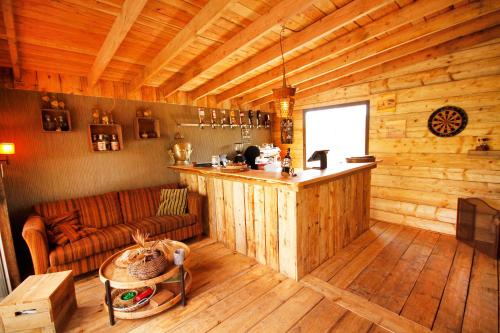 una sala de estar con sofá y un bar en una cabaña en Bamboo Lodge Groningen, en Groninga