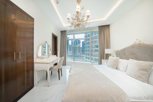a bedroom with a bed and a desk with a desk at Luton Vacation Homes - Park Island, marina view-Dubai Marina-60AB5 in Dubai