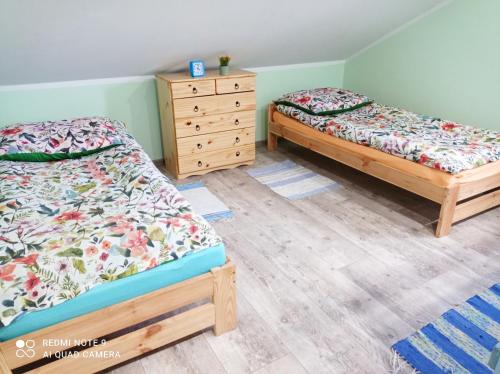 1 dormitorio con 2 camas y vestidor en Domek przy stajni, en Gajrowskie