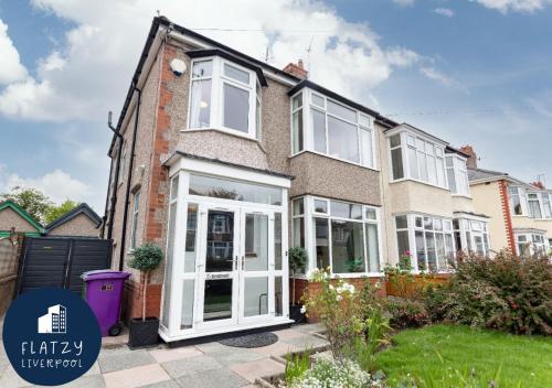 a large house with white doors and windows at Flatzy - Charming Garden Annexe in Aigburth with Kitchenette in Liverpool