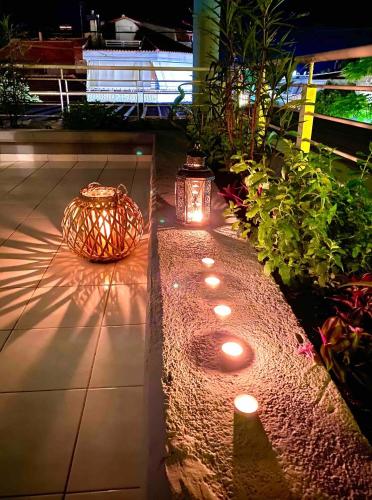 a garden with lights and plants on a sidewalk at Downtown apartment in Kamena Vourla