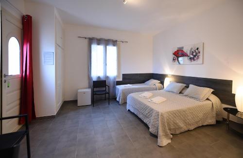 a hotel room with a bed and a dresser at Hôtel A casa di Maria Cicilia in Ghisonaccia