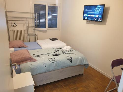 a bedroom with two beds and a flat screen tv at NEW CHEAP PRIVATE ROOM, KITCHEN , OVERWIEUW sea,TRAM on spot, 12 minutes from nice train station with tram , beach in 17 min tram , CHAMBRE PRIVÉE pas cher, cuisine équipée , tram sur place, APERÇU mer, 12 min de la gare de Nice avec le tram, 17 min plage in Nice