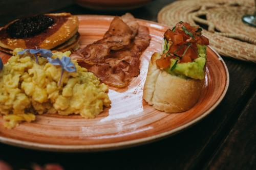a plate of breakfast foods on a table at Viajero Tayrona Hostel & Ecohabs in Buritaca