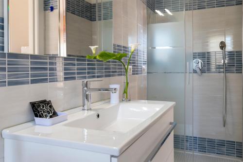a white sink in a bathroom with a shower at Sardinia rooms in Alghero