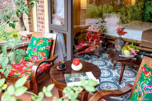 a patio with a table and chairs and a tableasteryasteryasteryasteryasteryastery at An's Eco Garden Resort in Ninh Binh