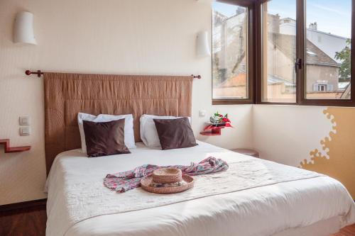 a bedroom with a bed with a hat on it at L'HÔTEL de CHARTRES in Chartres