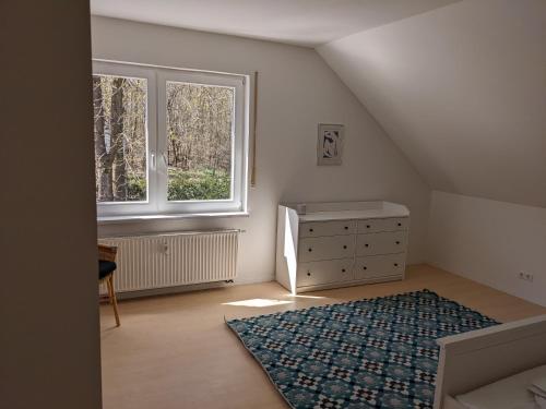 an attic room with a dresser and a window at Haus Eisfenn in Blankenheim
