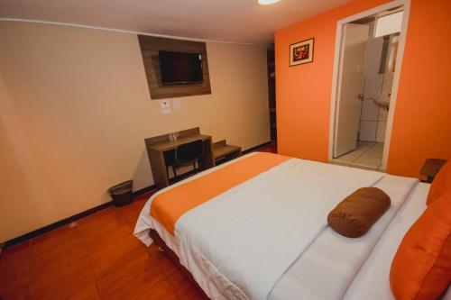 a bedroom with a large bed and a bathroom at Hotel Sol de Belén Cajamarca in Cajamarca