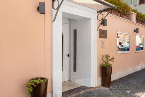 a white door on a building with two potted plants at Hotel Parker - Gruppo BLAM HOTELS in Rome