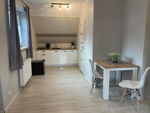 a kitchen with a table and chairs in a room at Maciejówka in Grywałd