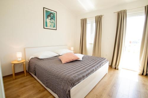 a bedroom with a bed with a gray and white comforter at BUKY HOUSE in Sumartin