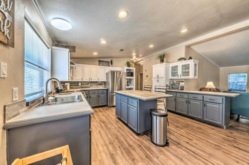 a large kitchen with stainless steel appliances and wood floors at Cozy Cloudcroft Cabin with Deck and Gas Grill! in Cloudcroft
