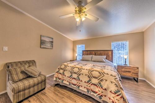 a bedroom with a bed and a ceiling fan and a chair at Cozy Cloudcroft Cabin with Deck and Gas Grill! in Cloudcroft