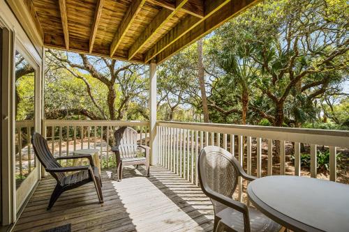 a porch with chairs and tables and a table at Seagrove 5-A in Isle of Palms