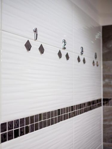 a shower with black and white tiles and faucets at Vienna Boutique - Premium Hostel in Vienna