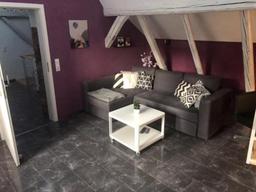 uma sala de estar com um sofá e uma mesa em Dachgeschosswohnung-15min vom Europa Park entfernt em Kenzingen