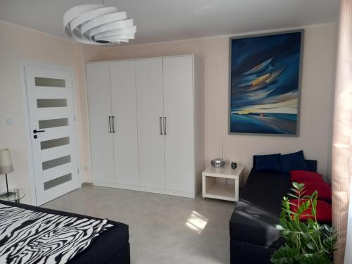 una camera con un letto, un divano e un quadro di Oaza spokoju a Lednogóra