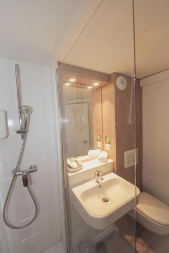 a bathroom with a shower and a sink and a toilet at Logis Hôtel Angers Sud in Angers