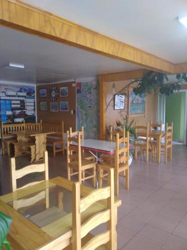 comedor con mesas y sillas de madera en hostal geminis ,phillipi 653 centro en Puerto Natales