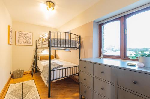 a bedroom with a bed and a dresser at Glan Morfa Lodge & Wildlife Experience in Dwyran