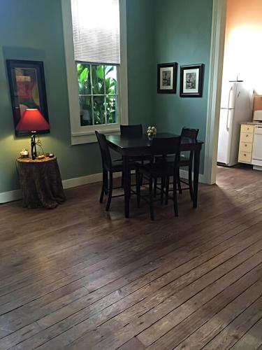 a dining room with a black table and chairs at Historic Viavant Cottage - Jazz Fest/FairGrounds in New Orleans