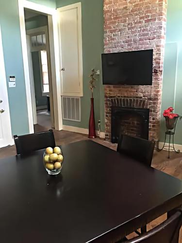 a dining room with a table and a fireplace at Historic Viavant Cottage - Jazz Fest/FairGrounds in New Orleans