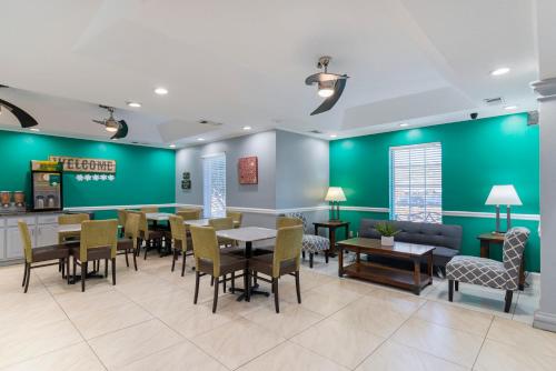 a dining room with green walls and tables and chairs at Quality Inn Newnan - Atlanta South in Newnan