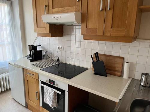 a kitchen with a sink and a stove top oven at A La Maison - hébergement de luxe in Domfront