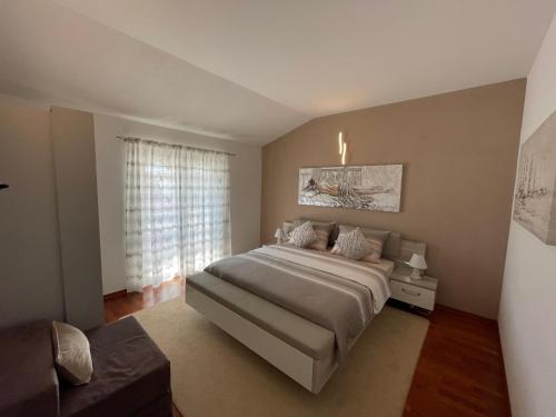 Un dormitorio con una cama grande y una ventana en Apartments Ozrenka, en Tučepi